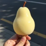 Pear Shaped Ice Cream: Where to Buy it & How to Make it at Home 9 hand holding light yellow pear shaped ice cream