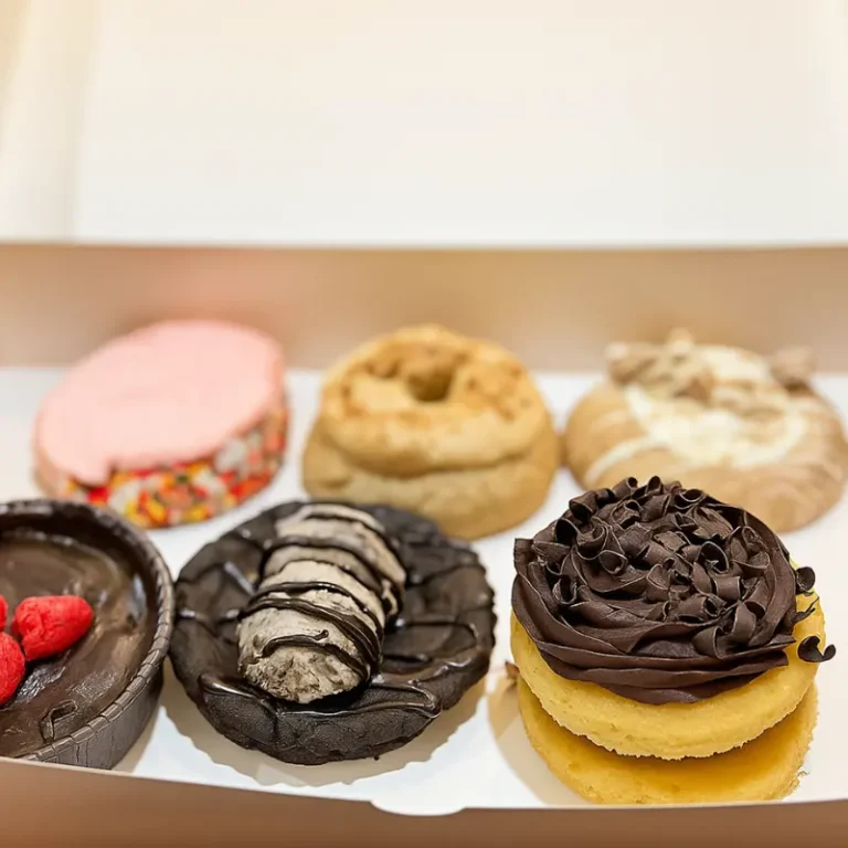 Crumbl Kardashian Cookies: 6 Delicious Picks to Try Right Now 8 A box of Crumbl Kardashian Cookies in assorted flavors including chocolate, pink frosting, and caramel toppings