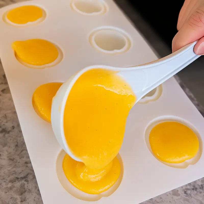 How To Make Orange Shaped Ice Cream 13 Hand pouring orange ice cream mix into silicone fruit molds