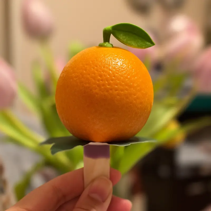 Best Vanilla Ninja Creami Healthy Recipes 2 orange shaped ice cream on a stick with green leaf base