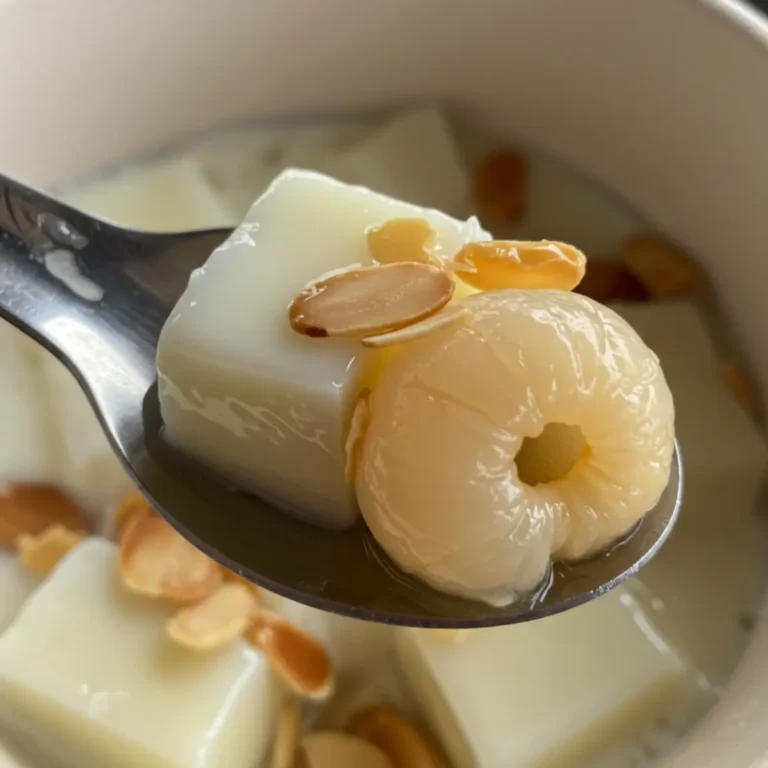 A serving of traditional Vietnamese panna cotta sweet soup, garnished with crunchy almonds.
