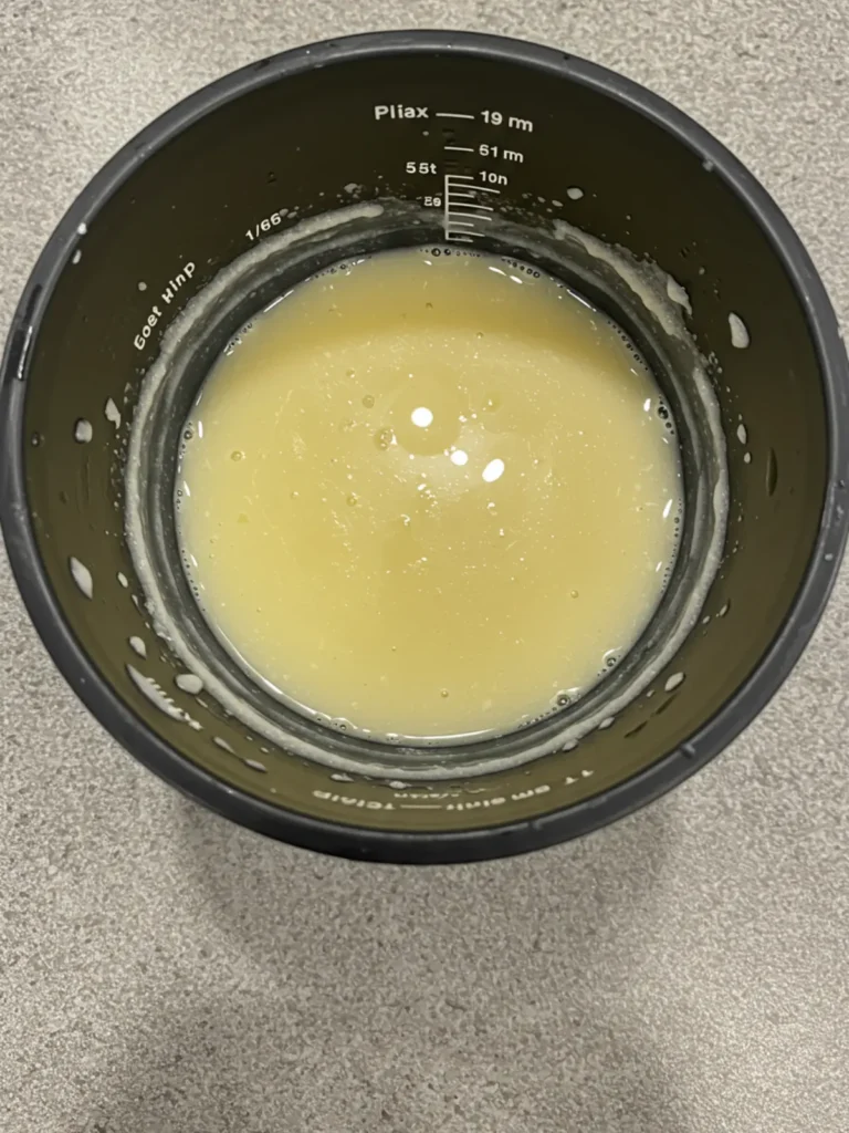A spoonful showing the creamy texture of a ninja creami dole whip recipe with pineapple chunks.